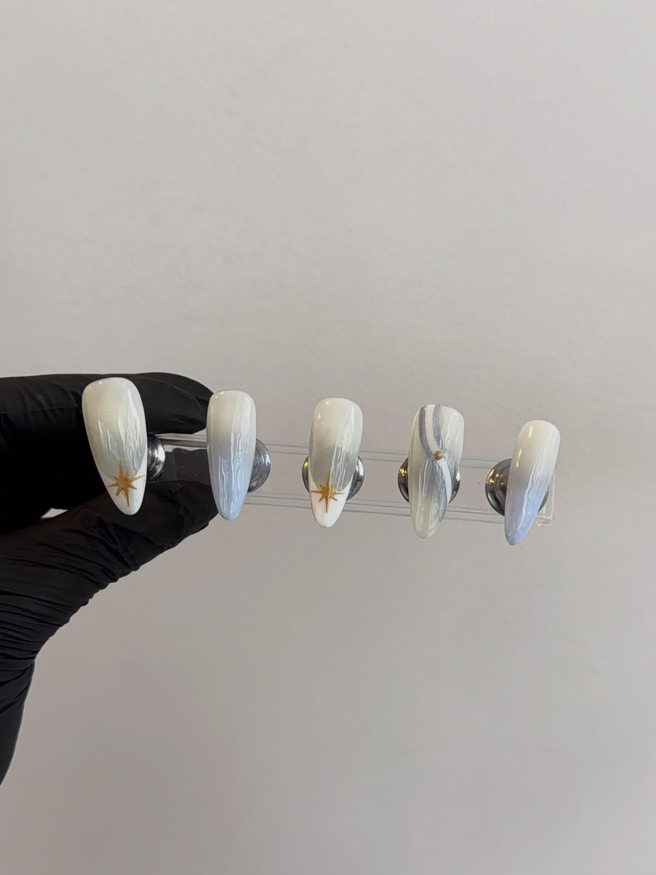 Diseño de uñas de Amari en tonos claros con detalles dorados